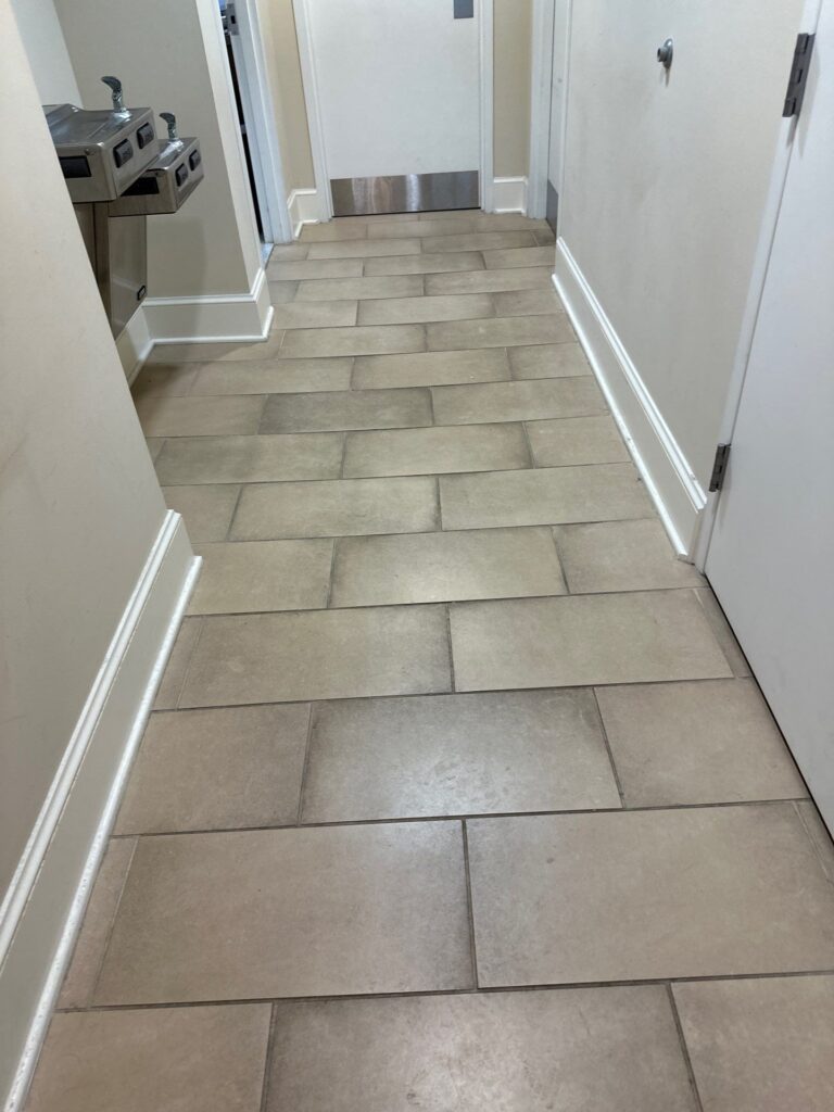 carpet masters doing a tile and grout cleaning project in a hallway.