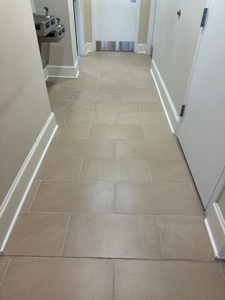 carpet masters doing a tile and grout cleaning project in a hallway area.