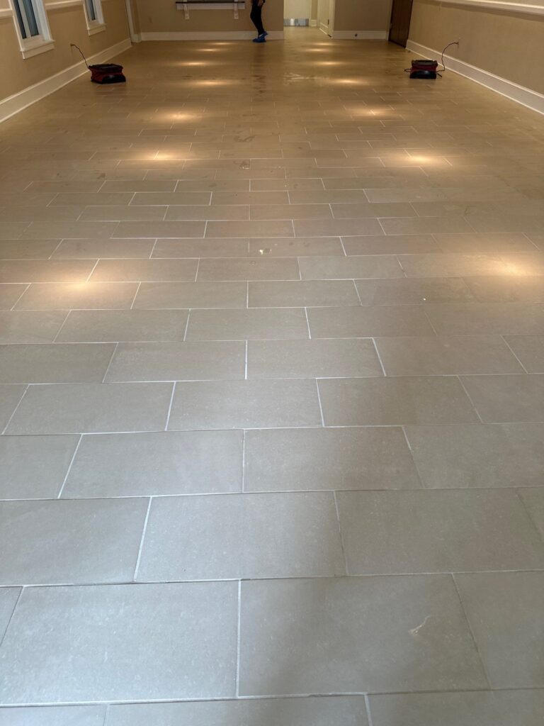 carpet masters doing a tile and grout cleaning project in a spacious area.